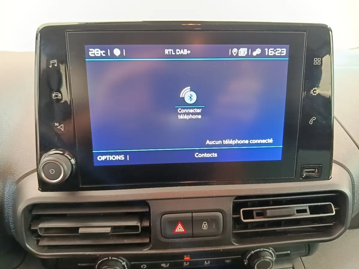 Écran tactile central du tableau de bord du Citroën Berlingo blanc, affichant la connexion Bluetooth au téléphone.