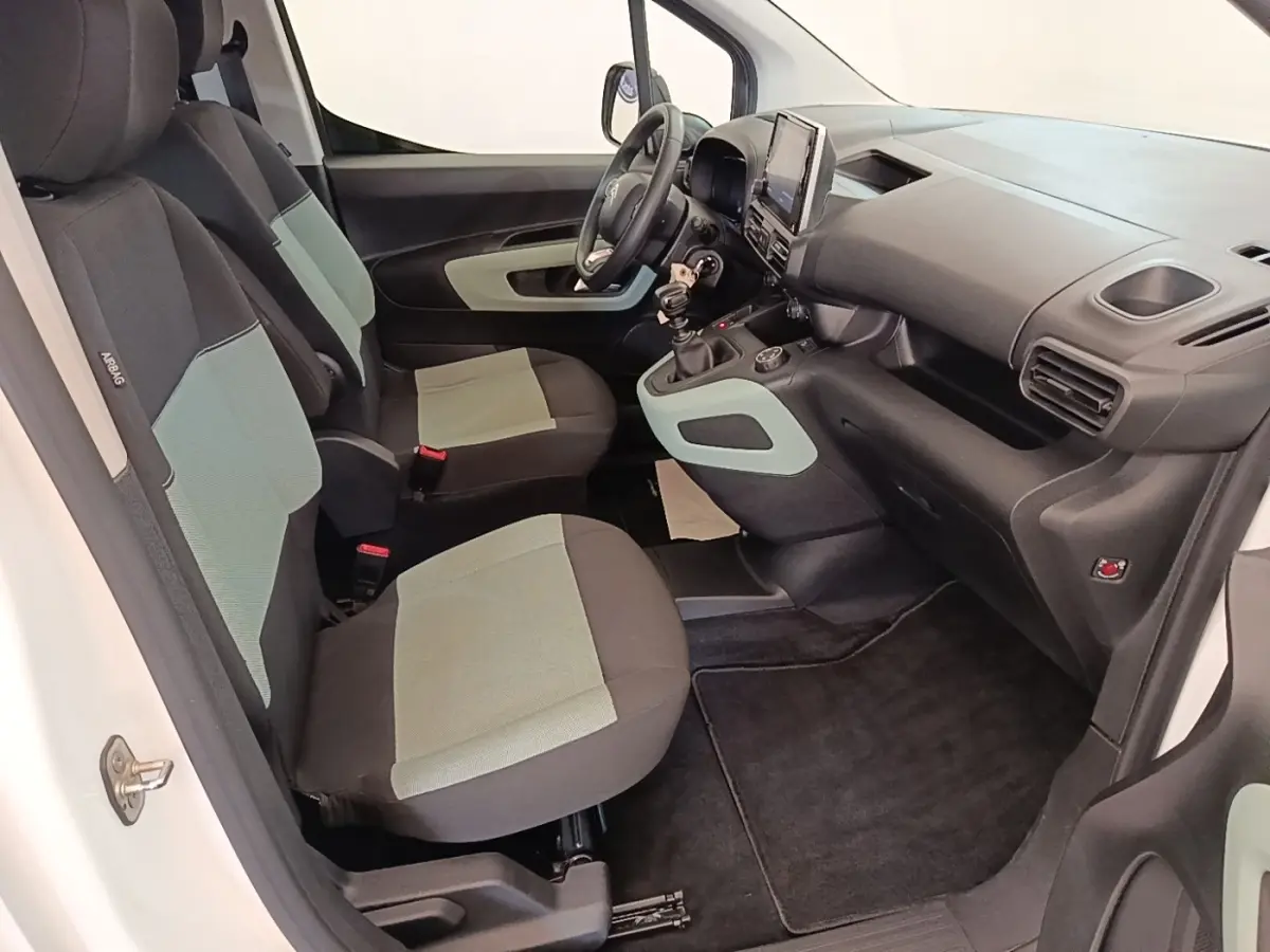 Vue intérieure côté conducteur du Citroën Berlingo blanc 2022, sièges bicolores et tableau de bord avec écran tactile.