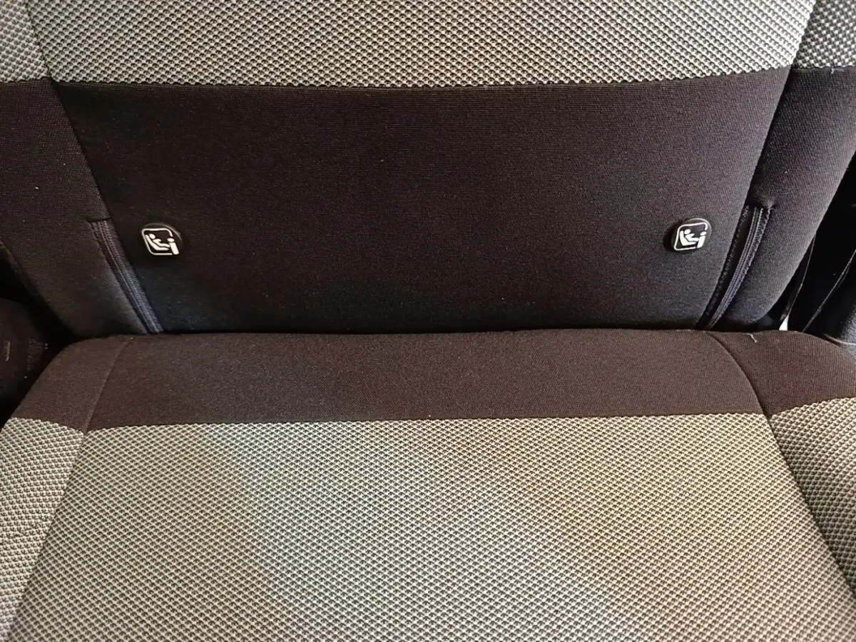 Gros plan sur la banquette arrière bi-ton gris et noir du Citroën Berlingo avec attaches Isofix visibles.