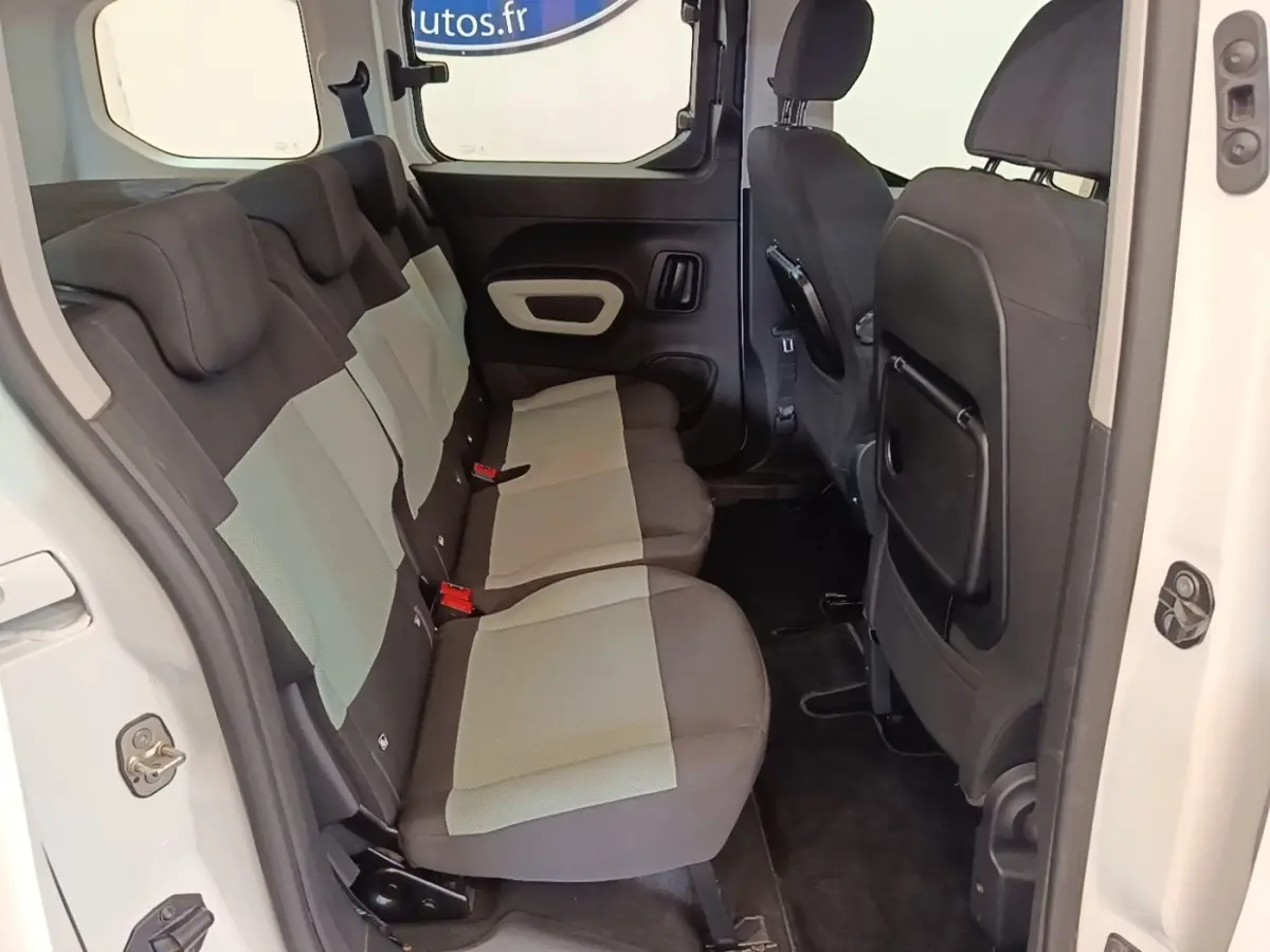 Vue intérieure côté gauche sur la banquette arrière bicolore grise et noire du Citroën Berlingo blanc 2022.