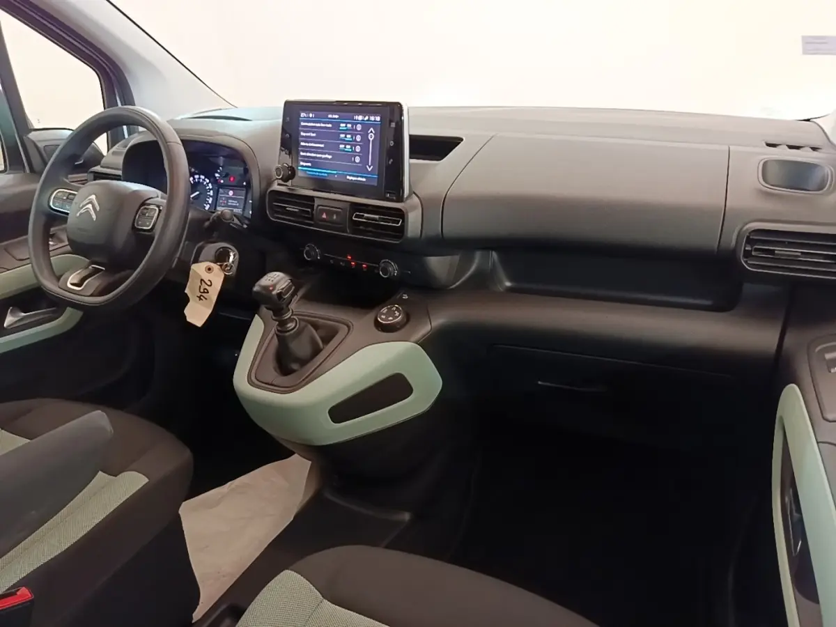 Vue intérieure avant droite du Citroën Berlingo blanc 2022, tableau de bord avec écran tactile et volant multifonctions.