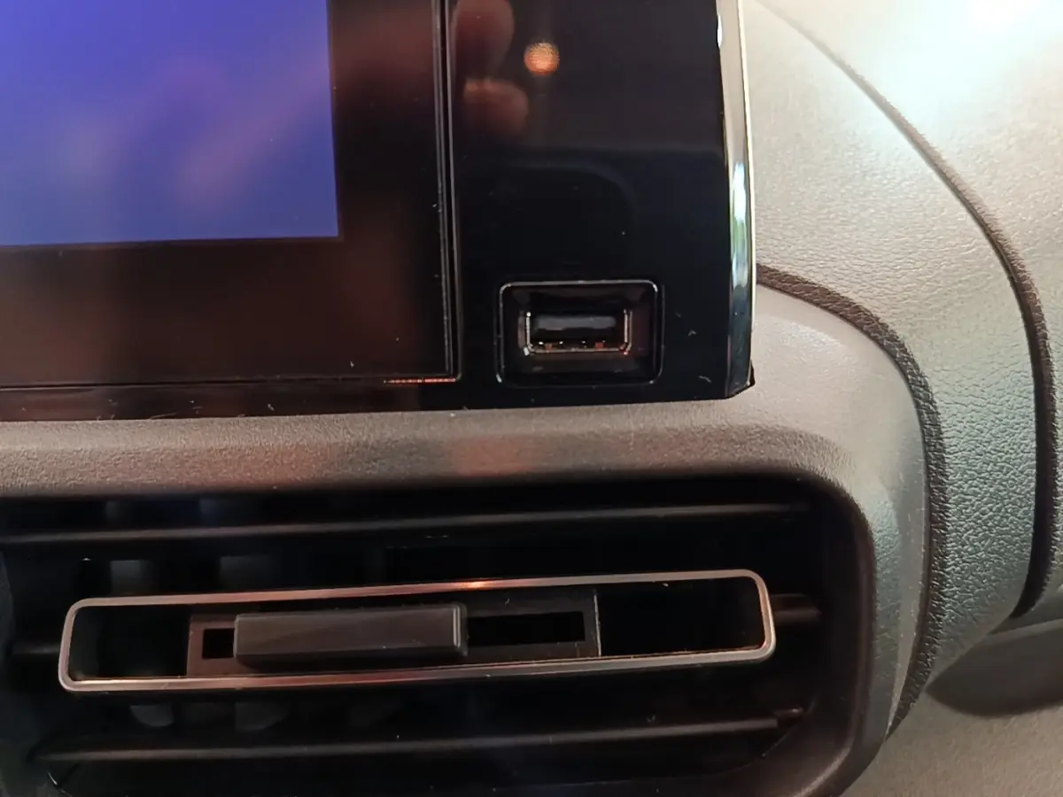 Détail de la console centrale du Citroën Berlingo blanc 2022, avec prise USB et sortie d'air rectangulaire.