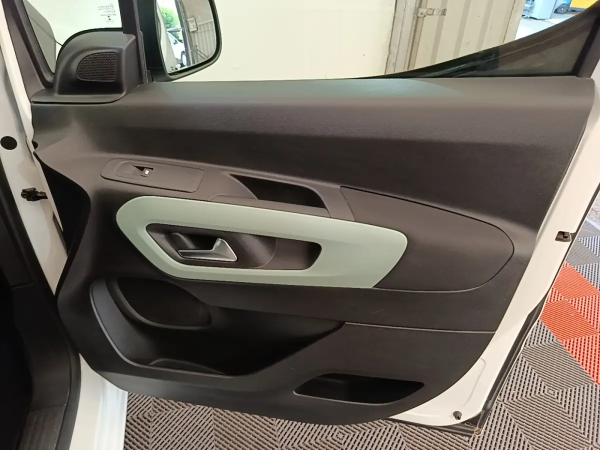 Vue rapprochée de la porte avant gauche blanche du Citroën Berlingo 2022 avec insert décoratif gris clair.