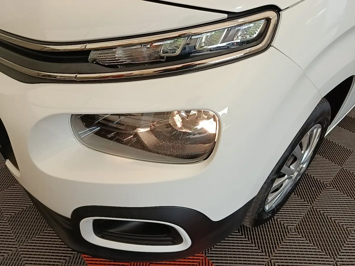 Gros plan sur l’avant droit blanc du Citroën Berlingo 2022, mettant en valeur les phares LED et antibrouillards.