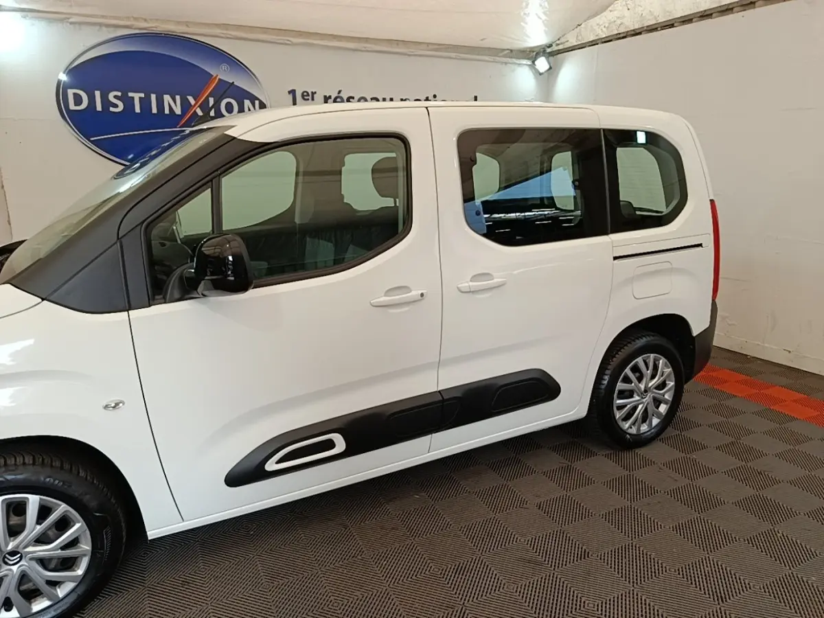 Vue de profil côté gauche du Citroën Berlingo blanc avec protections latérales noires et jantes alliage.