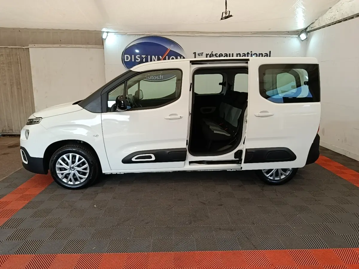 Profil droit d'un Citroën Berlingo blanc 2022 avec porte coulissante ouverte, intérieur visible et jantes alliage.