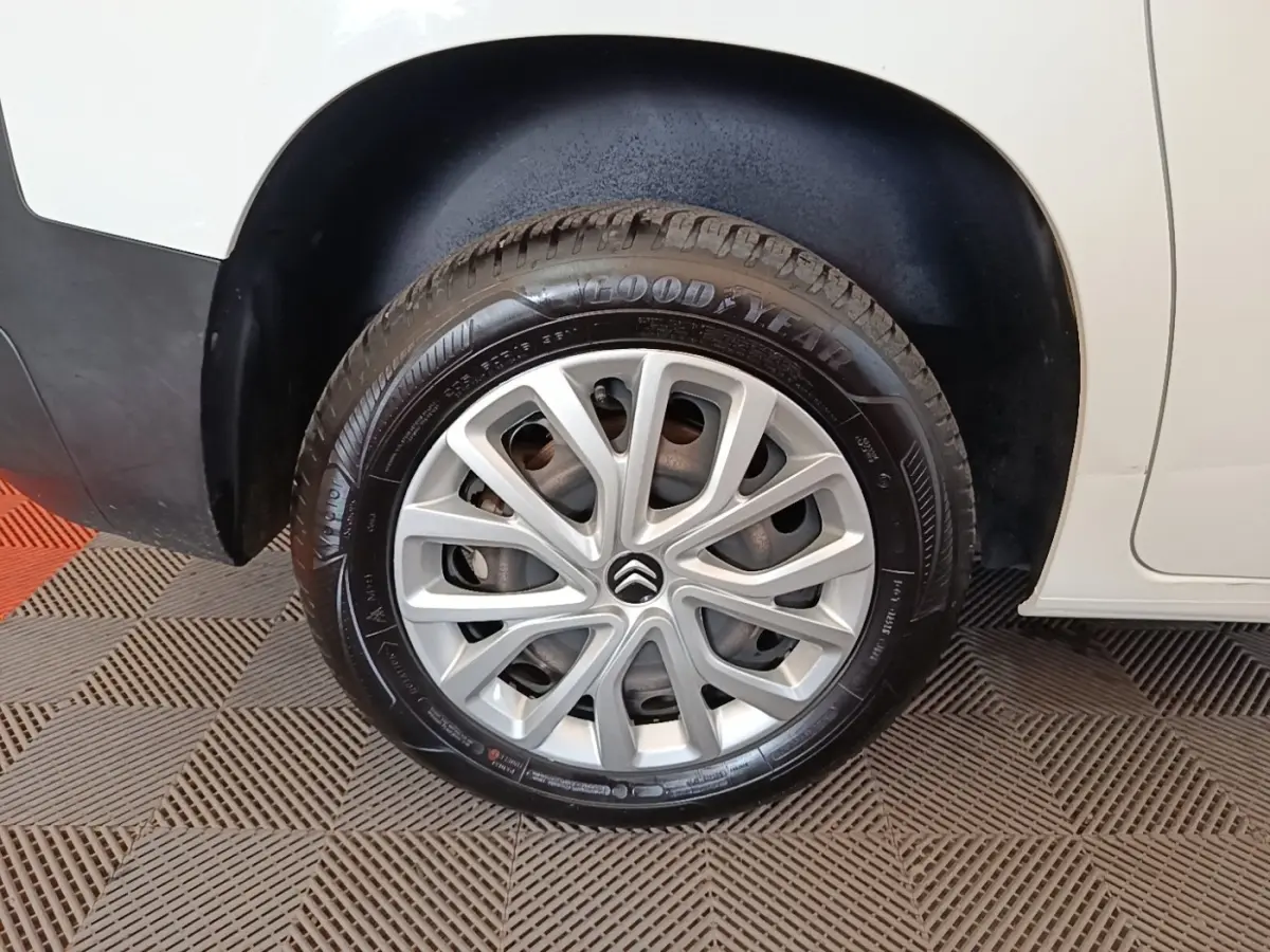 Gros plan sur la roue arrière droite blanche d'un Citroën Berlingo 2022 avec jante argentée et pneu Goodyear.