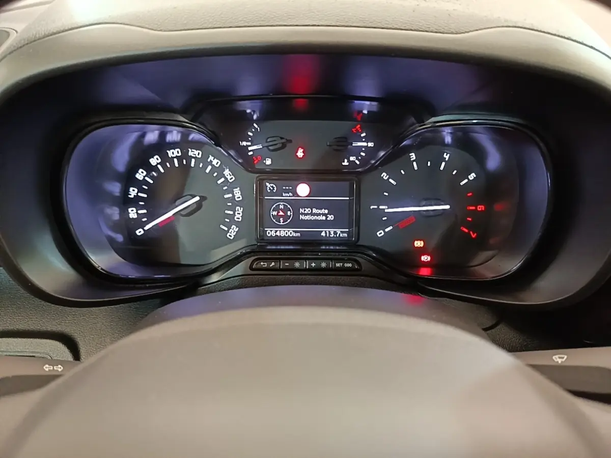 Vue rapprochée du tableau de bord noir du Citroën Berlingo 2022 avec affichage numérique et compteurs analogiques.