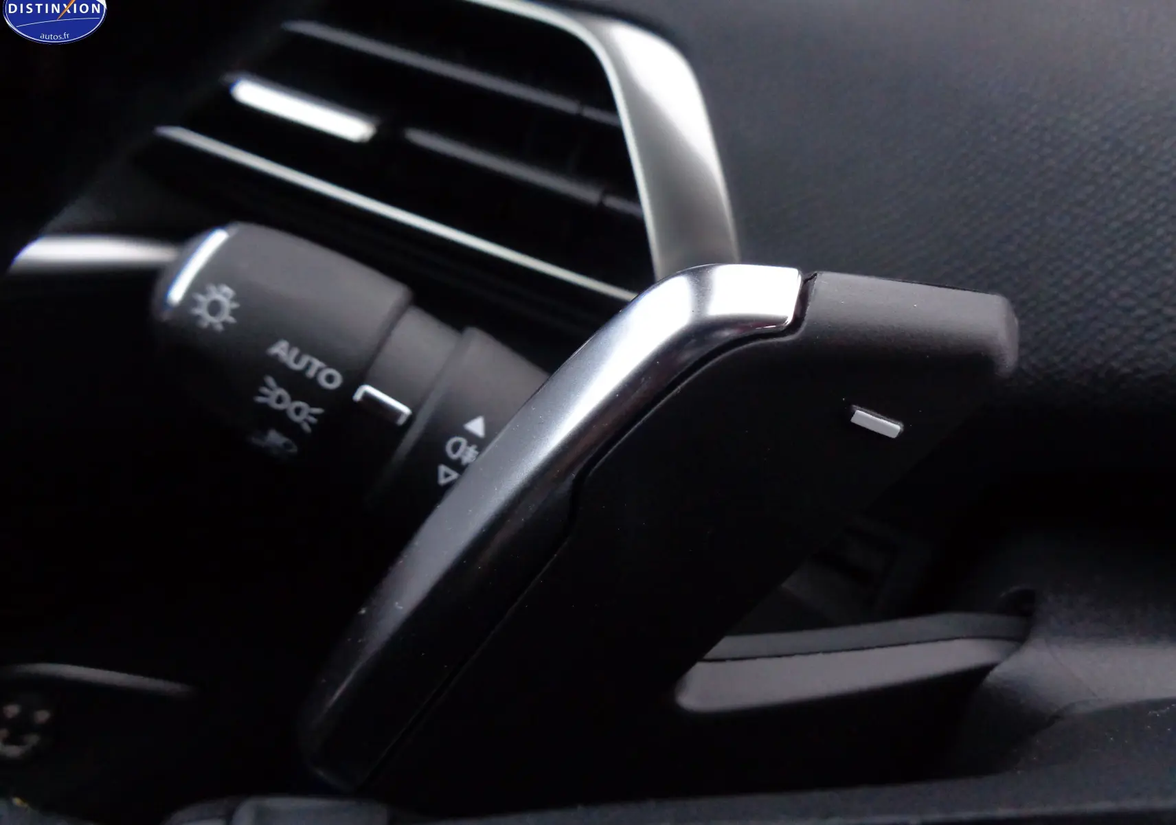 Gros plan sur la palette de changement de vitesse noire et argentée du Peugeot 3008 gris platinium 2023, côté gauche du volant.