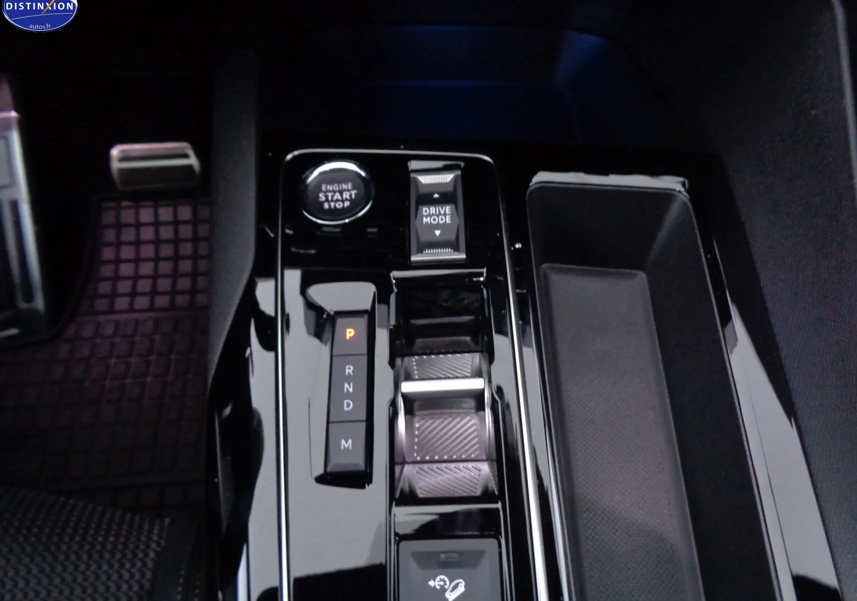 Gros plan sur la console centrale noire brillante du Peugeot 3008 gris platinium, montrant le bouton start/stop et la commande de boîte auto.