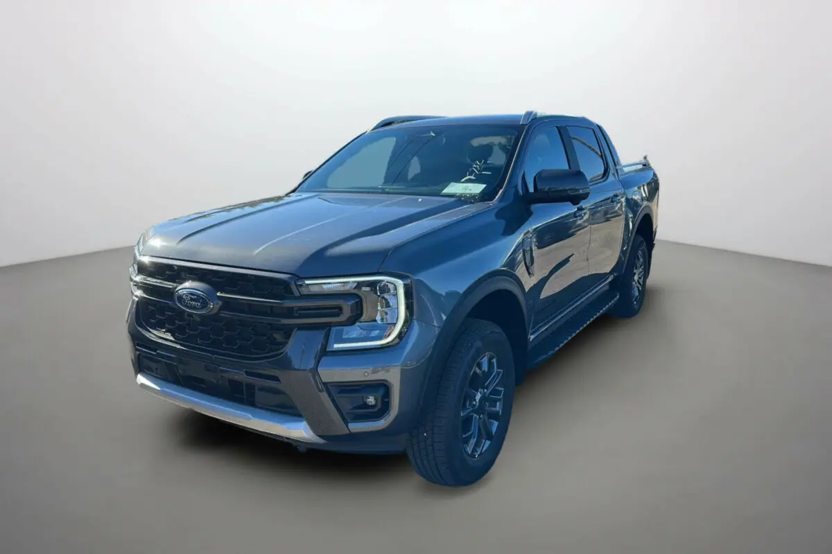 Ford Ranger 2025 gris carbone en 3/4 avant droit avec jantes alu 18 pouces et calandre noire distinctive.