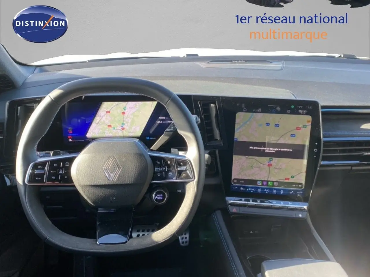 Intérieur Renault Austral E-Tech 2024 vu du poste de conduite, volant multifonction et écran tactile central affichant une carte.