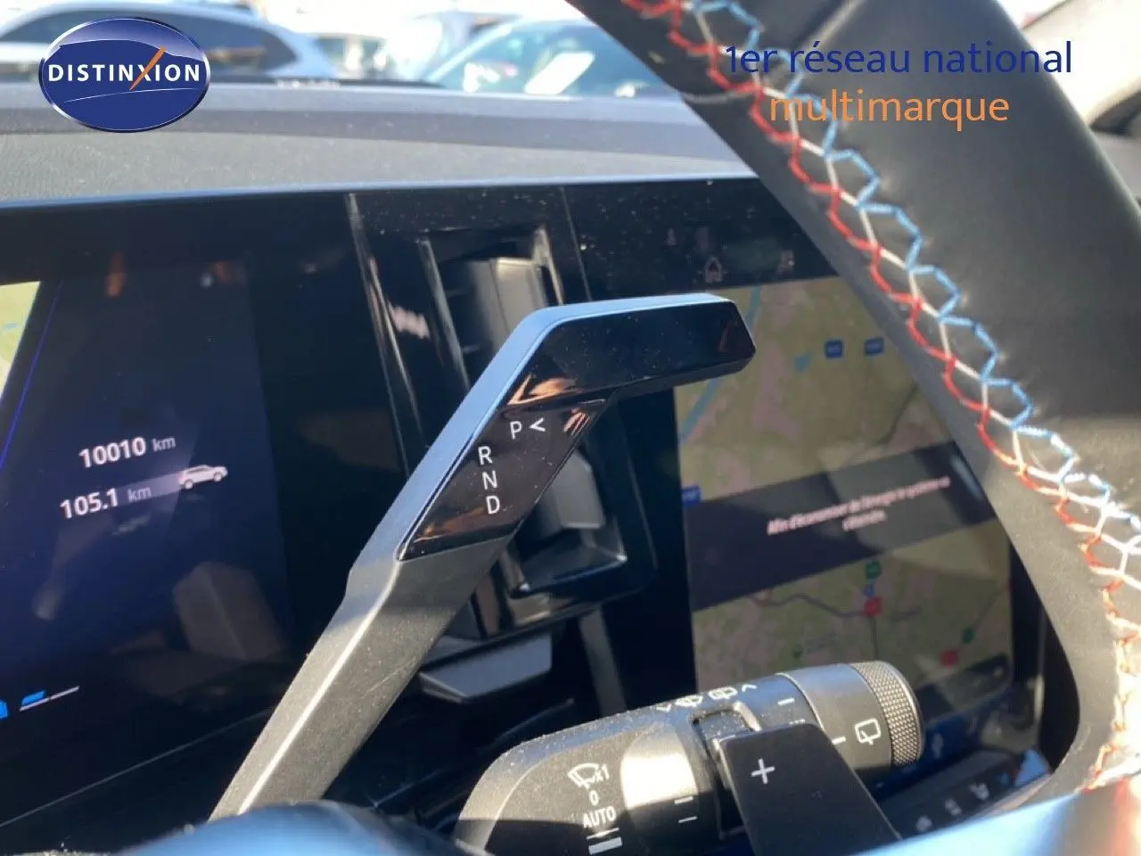 Gros plan sur la commande de boîte automatique à palettes dans l'habitacle du Renault Austral blanc nacré 2024.