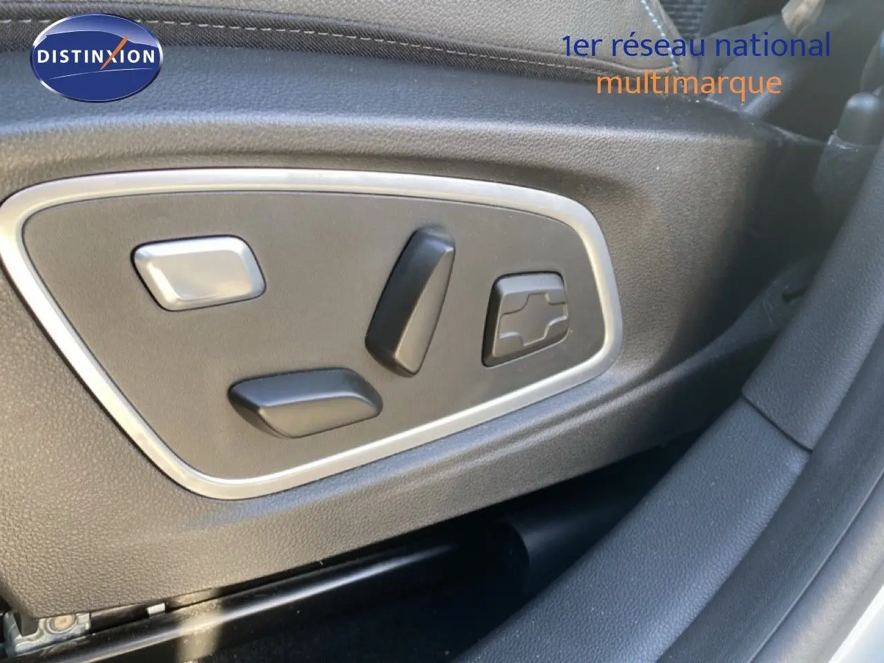 Gros plan sur les commandes électriques du siège conducteur du Renault Austral blanc nacré toit noir 2024.