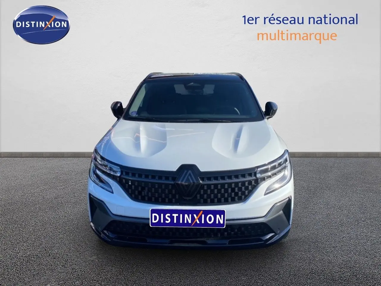 Vue frontale d'un Renault Austral blanc nacré avec toit noir, mettant en valeur sa calandre et ses phares LED modernes.