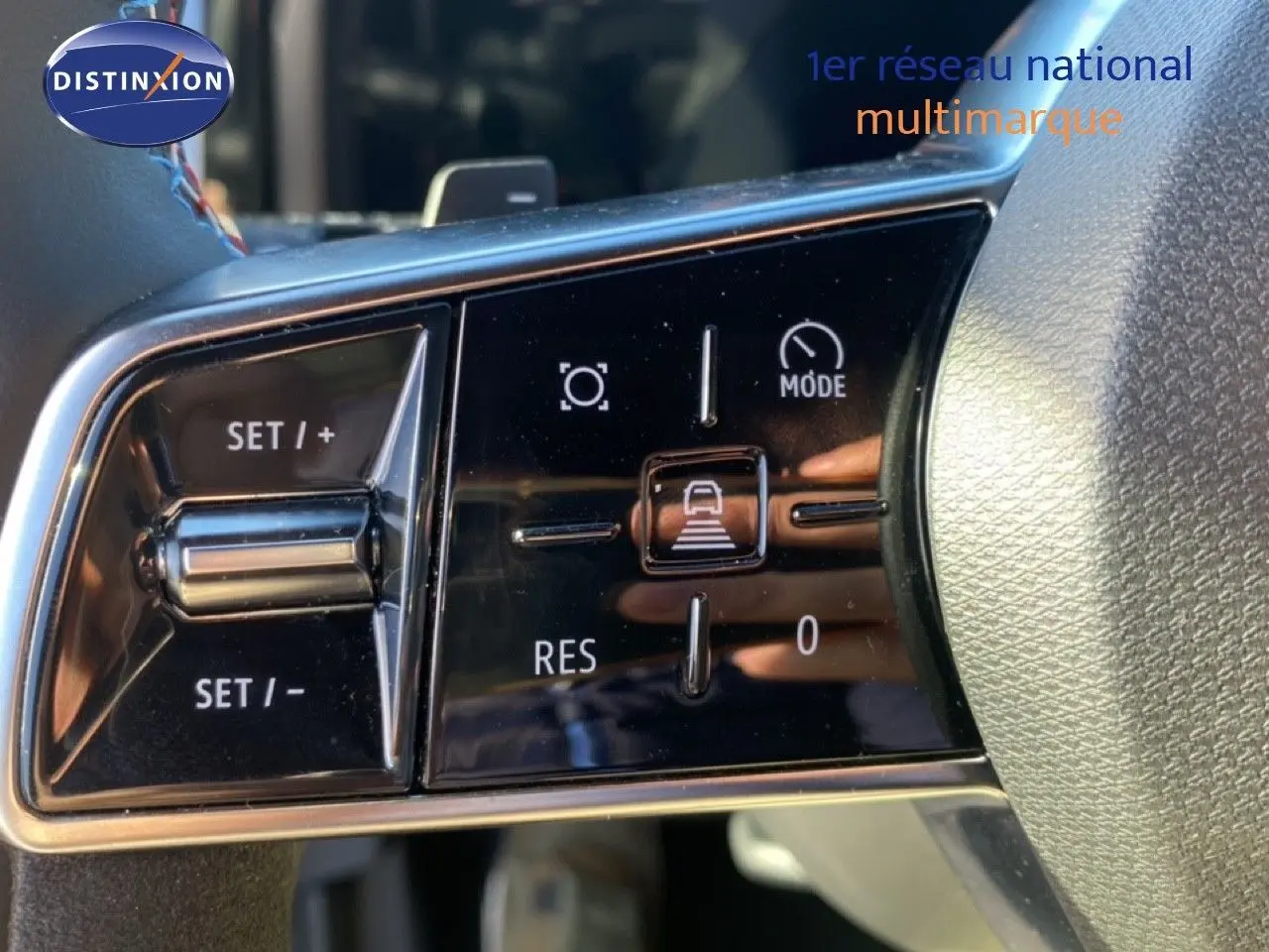 Gros plan sur les commandes de régulateur de vitesse au volant du Renault Austral blanc nacré 2024.