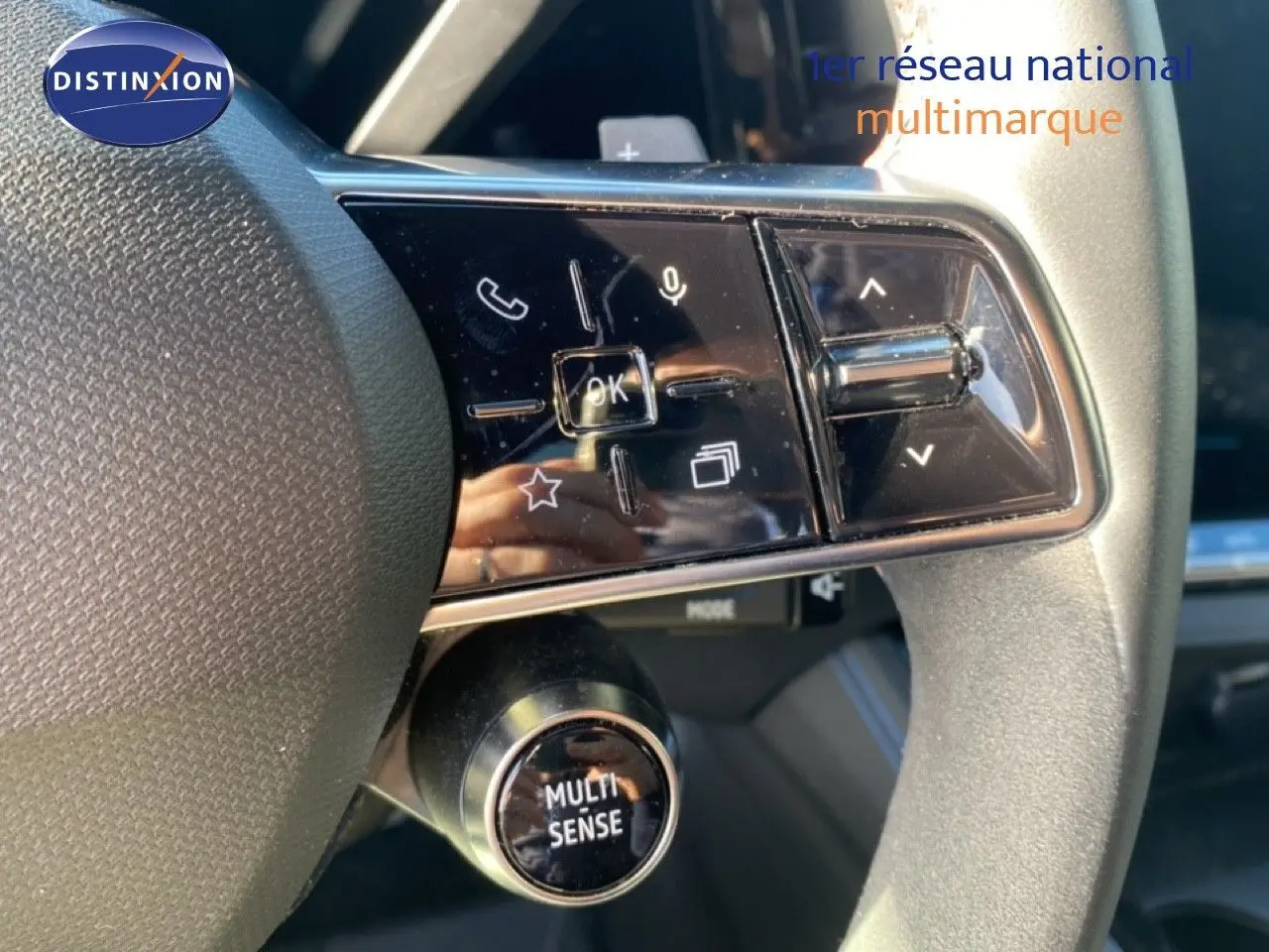 Gros plan sur les commandes du volant du Renault Austral 2024 blanc nacré avec bouton Multi-Sense et touches multifonctions.