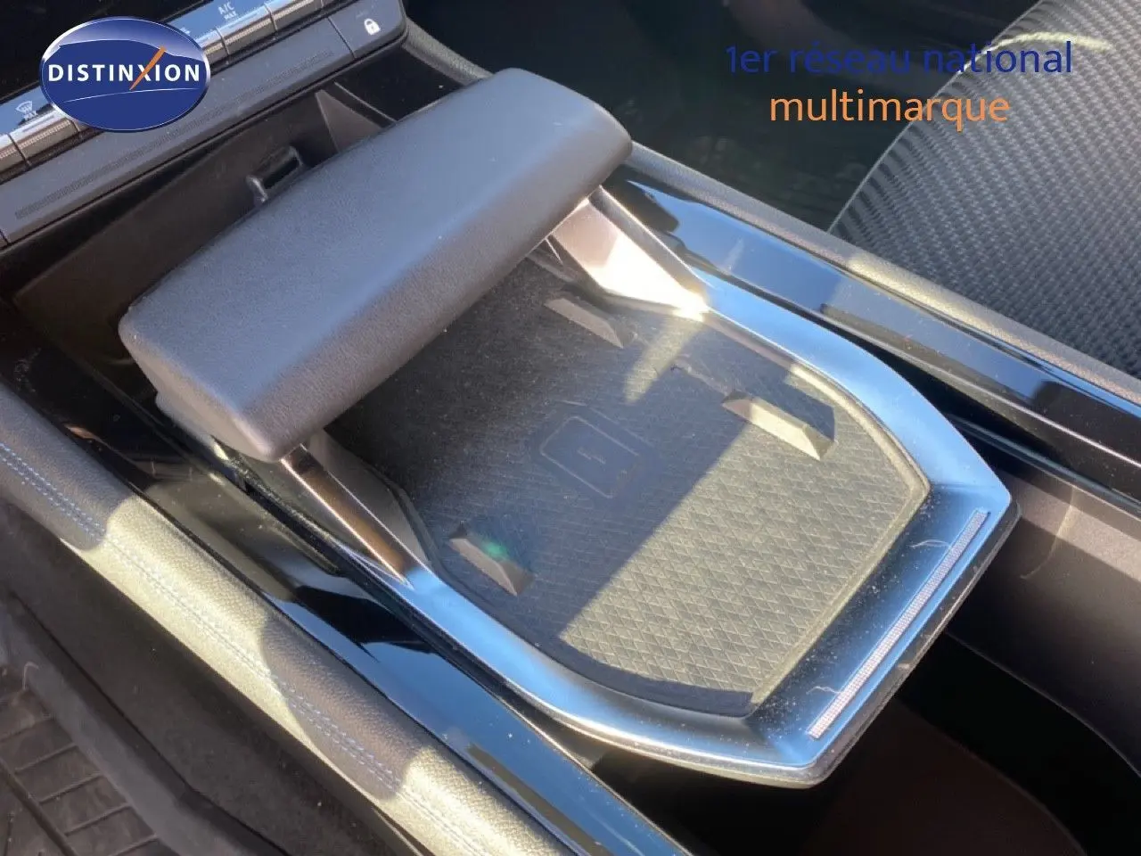 Plateau de recharge sans fil et accoudoir central dans l'habitacle noir du Renault Austral E-Tech 2024.