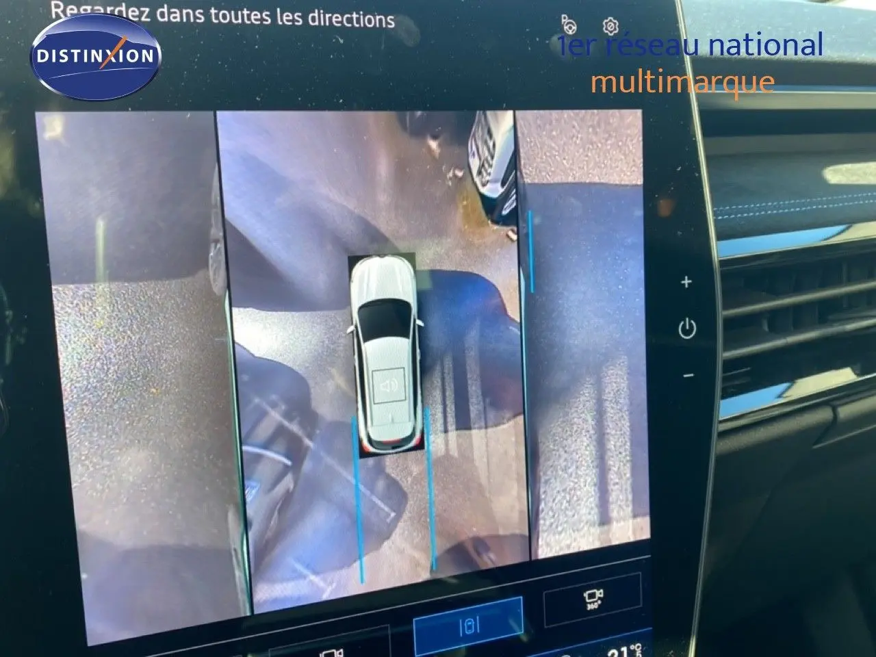 Vue intérieure de l'écran multimédia affichant la caméra 360° du Renault Austral blanc nacré toit noir en stationnement.