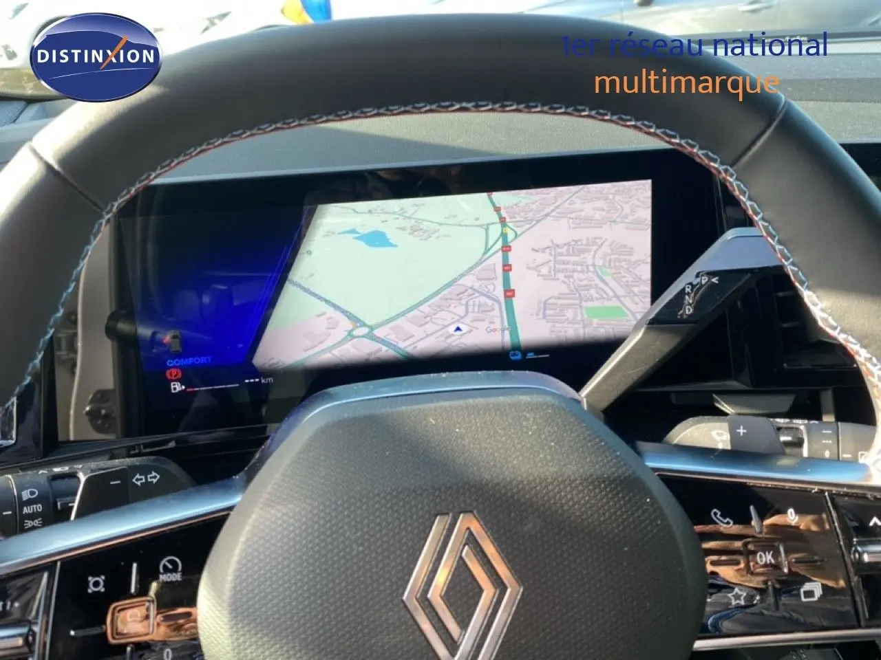 Vue rapprochée du volant et du tableau de bord numérique du Renault Austral blanc nacré avec toit noir, affichant la navigation.