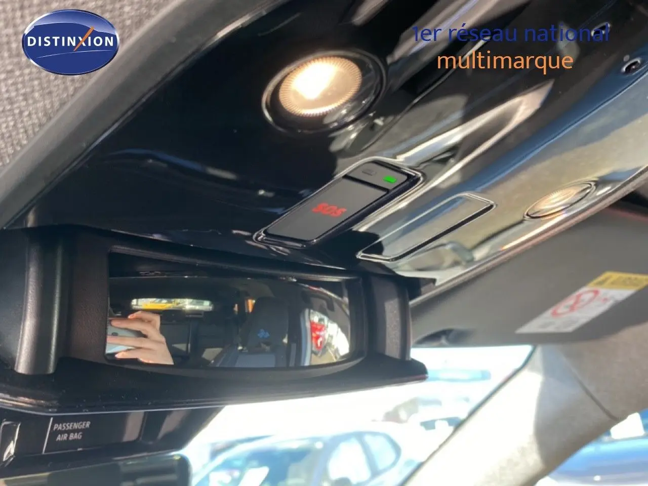 Vue rapprochée du plafonnier noir brillant avec bouton SOS et miroir intérieur du Renault Austral blanc nacré toit noir.