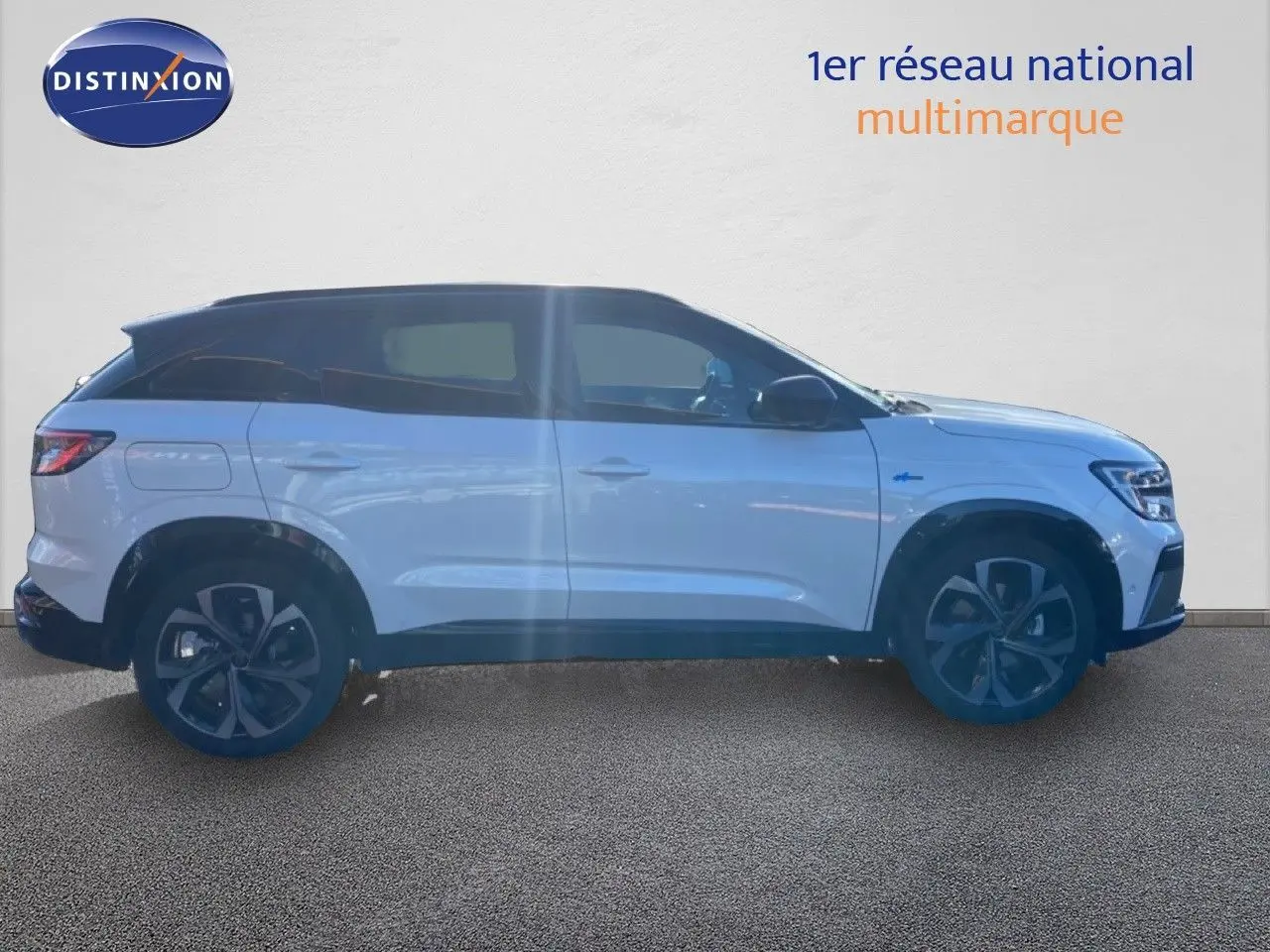 Profil droit du Renault Austral blanc nacré avec toit noir, mettant en valeur ses jantes et lignes modernes.