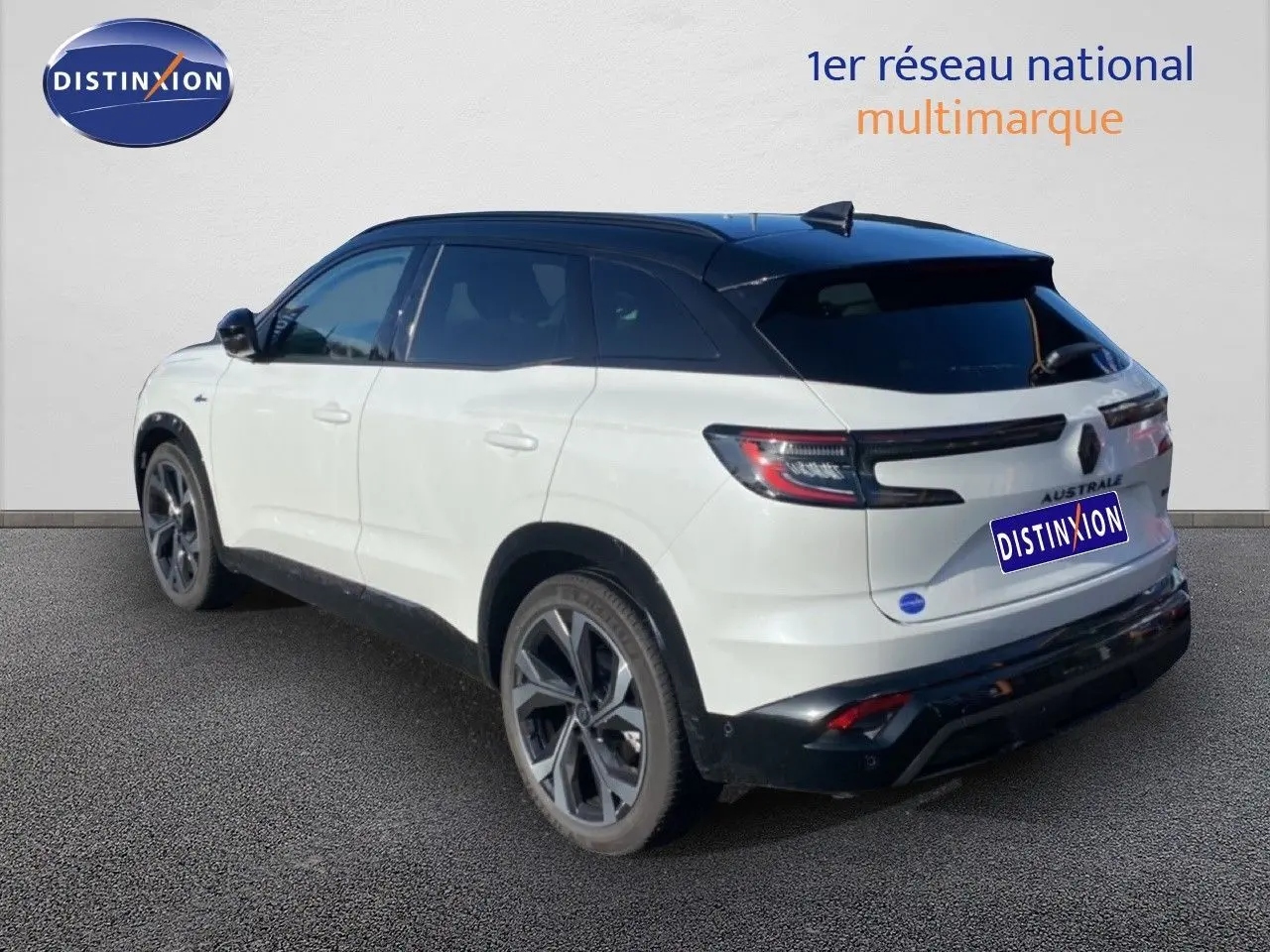Renault Austral E-Tech blanc nacré avec toit noir, vue 3/4 arrière côté gauche, jantes alliage distinctives.