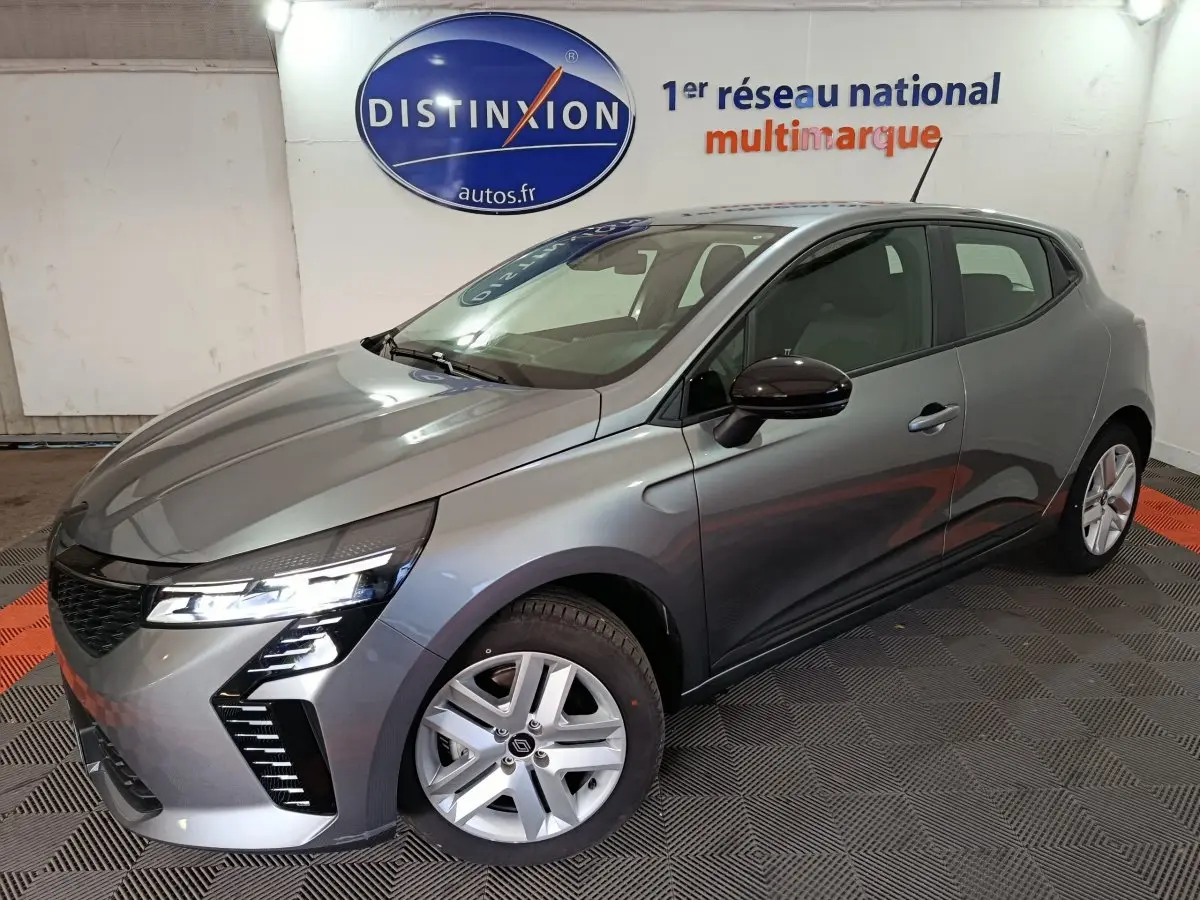 Renault Clio Evolution Blue dCi 100 gris clair vue 3/4 avant droit, phares LED allumés, jantes alliage et rétroviseurs noirs.