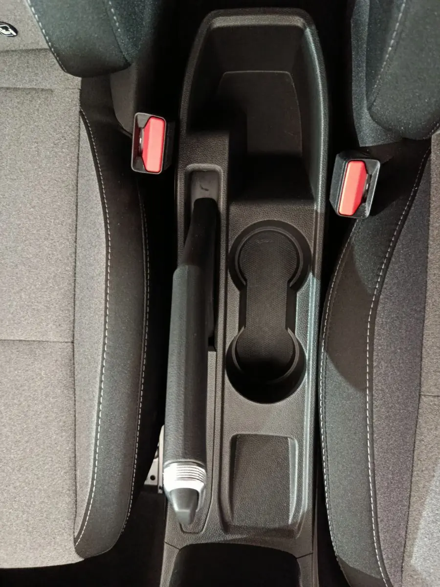 Vue plongeante sur la console centrale noire et les sièges gris foncé de la Renault Clio Evolution Blue dCi 100 de 2025.