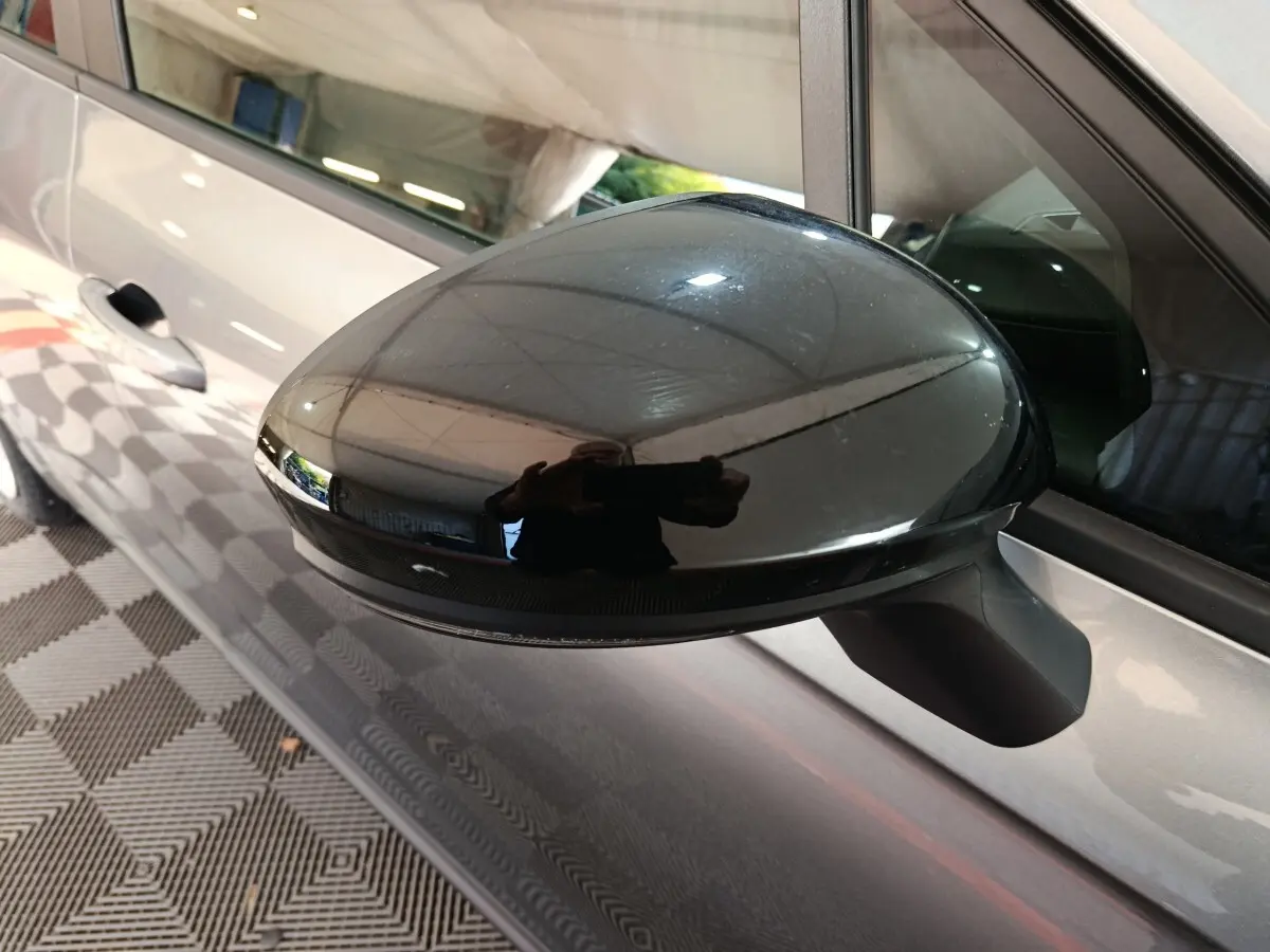 Rétroviseur noir en gros plan côté gauche sur Renault Clio gris clair Evolution Blue dCi 100, vue latérale partielle.