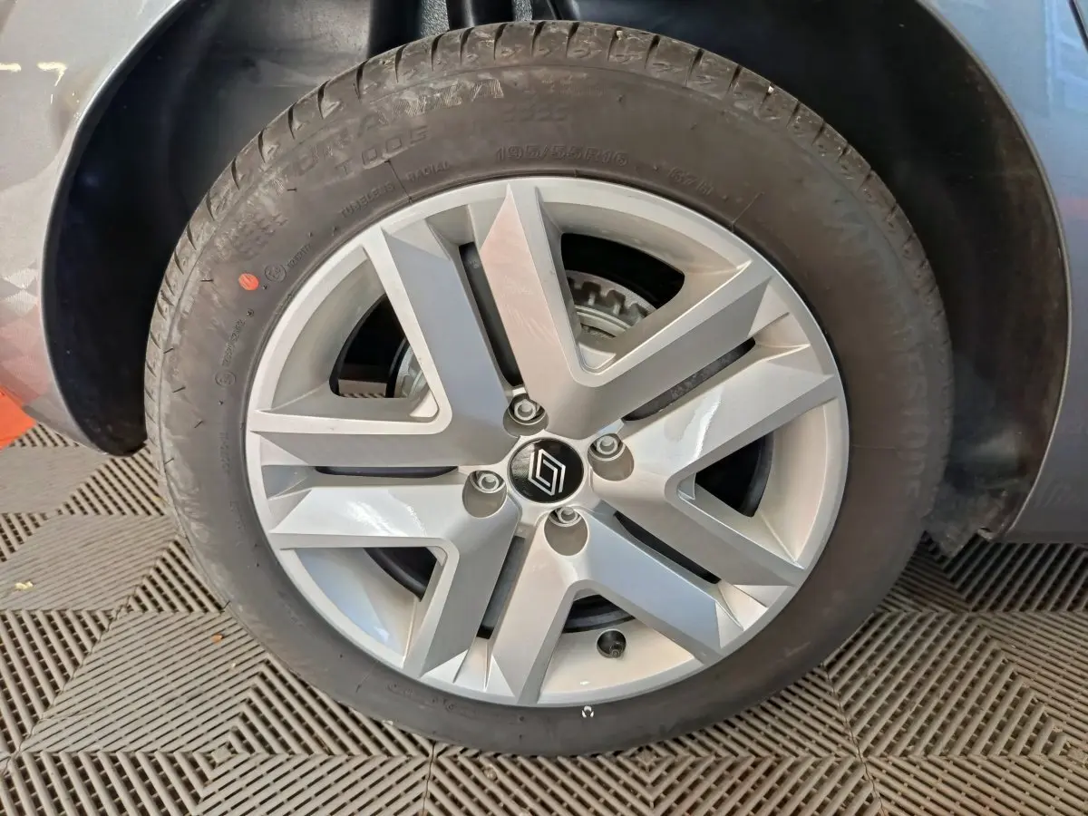 Gros plan sur la roue arrière droite d'une Renault Clio gris clair Evolution Blue dCi 100, montrant le passage de roue et le pneu.