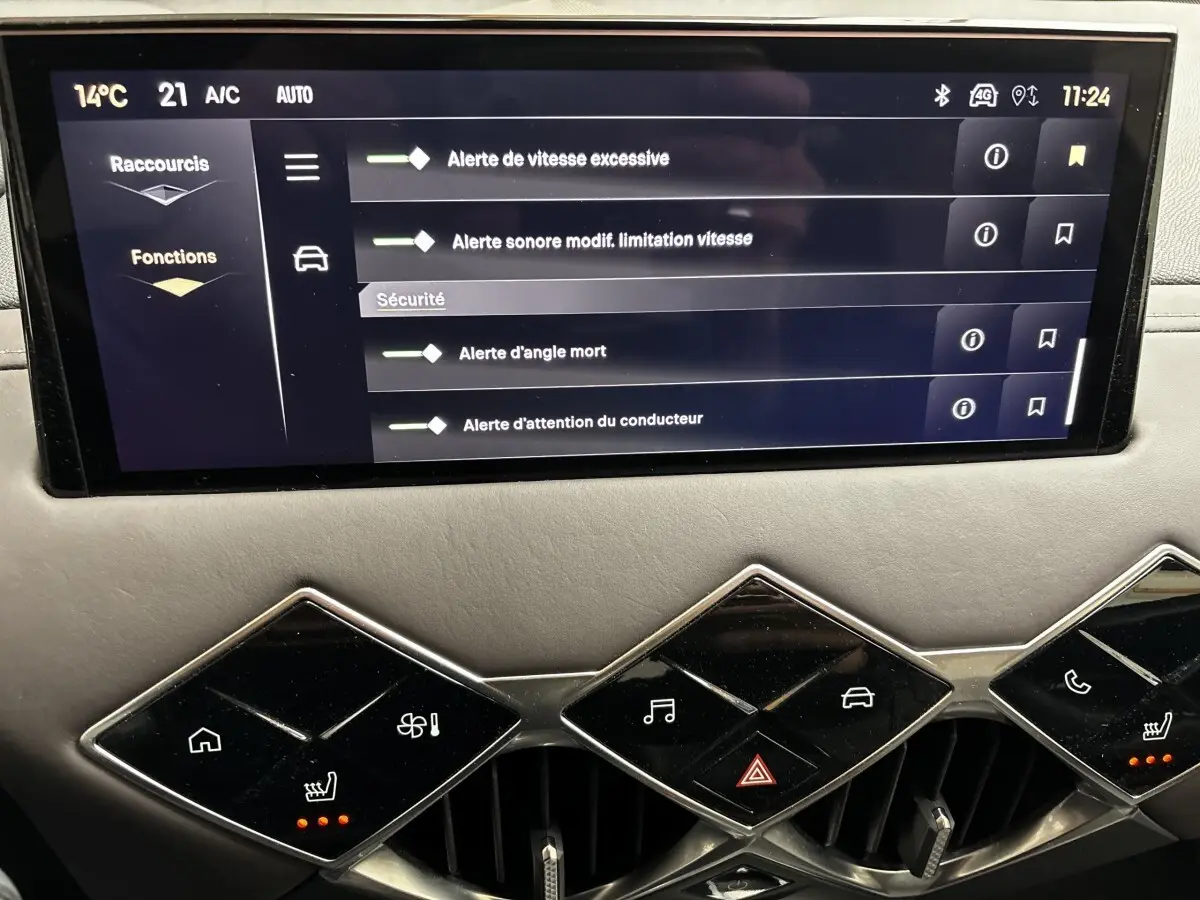 Écran tactile central du tableau de bord du DS3 2024 gris foncé, avec commandes climatisation et alertes sécurité affichées.