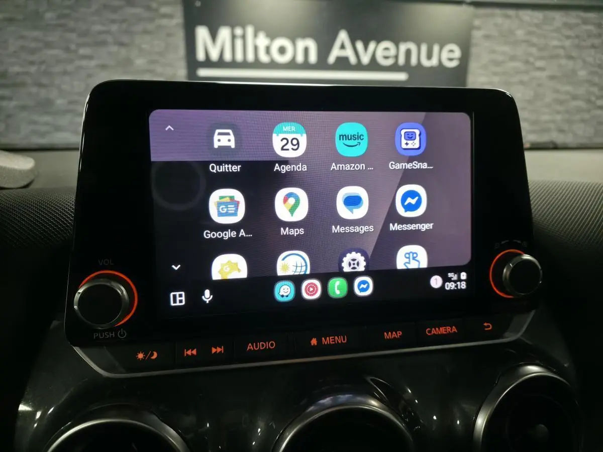 Écran tactile 8 pouces du Nissan Juke 2023 gris, vue rapprochée du tableau de bord avec commandes audio et navigation.