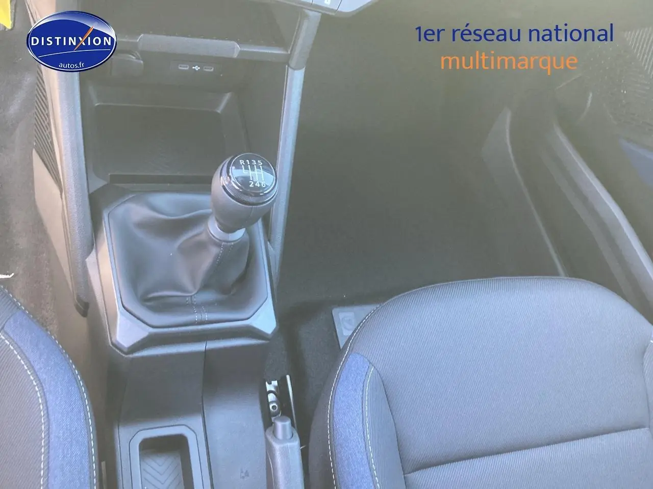 Vue intérieure centrée sur le levier de vitesses manuel et le siège avant droit du Dacia Duster noir 2025.