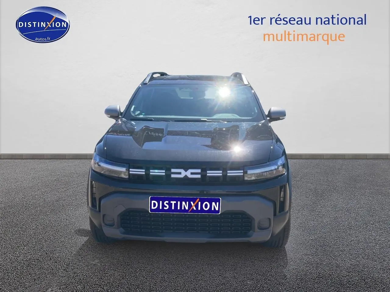 Vue frontale d'un Dacia Duster noir 2025 avec calandre moderne et phares LED fins allumés.