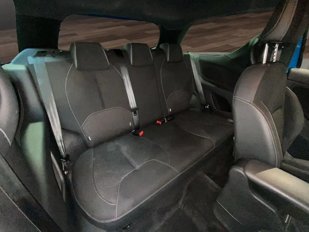 Vue intérieure sur la banquette arrière noire de la Citroën DS3 e-HDi 90 Airdream So Chic bleu, sièges tissu avec ceintures visibles.