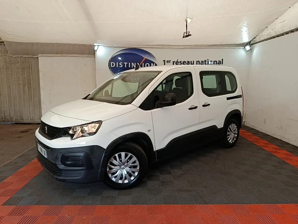 Peugeot Rifter blanc en 3/4 avant droit, avec protections noires sur les bas de caisse et jantes argentées.