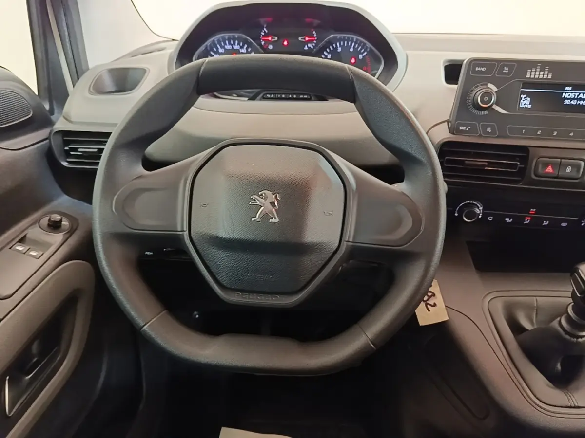Vue intérieure centrée sur le volant noir du Peugeot Rifter 2020, avec tableau de bord et console centrale visibles.