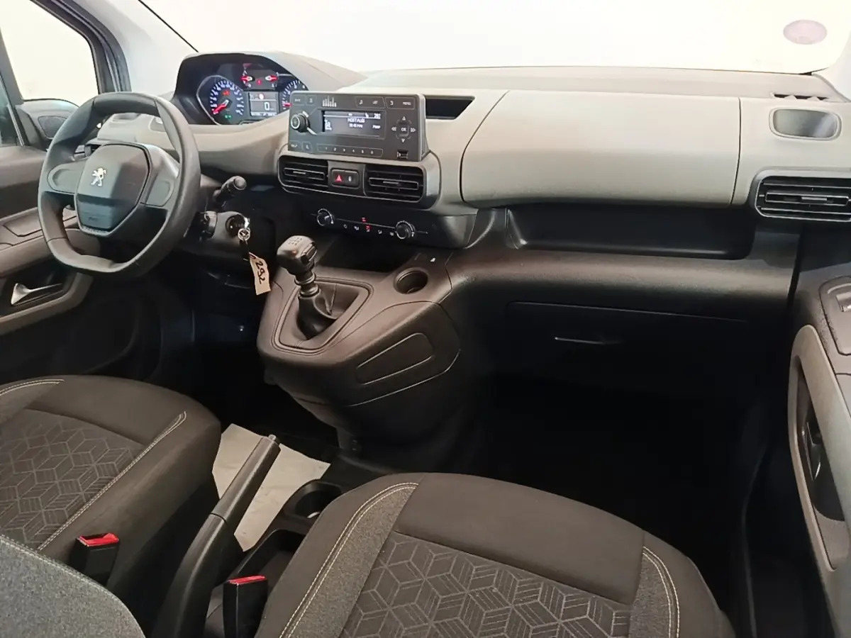 Intérieur avant du Peugeot Rifter blanc, vue côté conducteur, tableau de bord avec volant compact et levier de vitesses manuel.