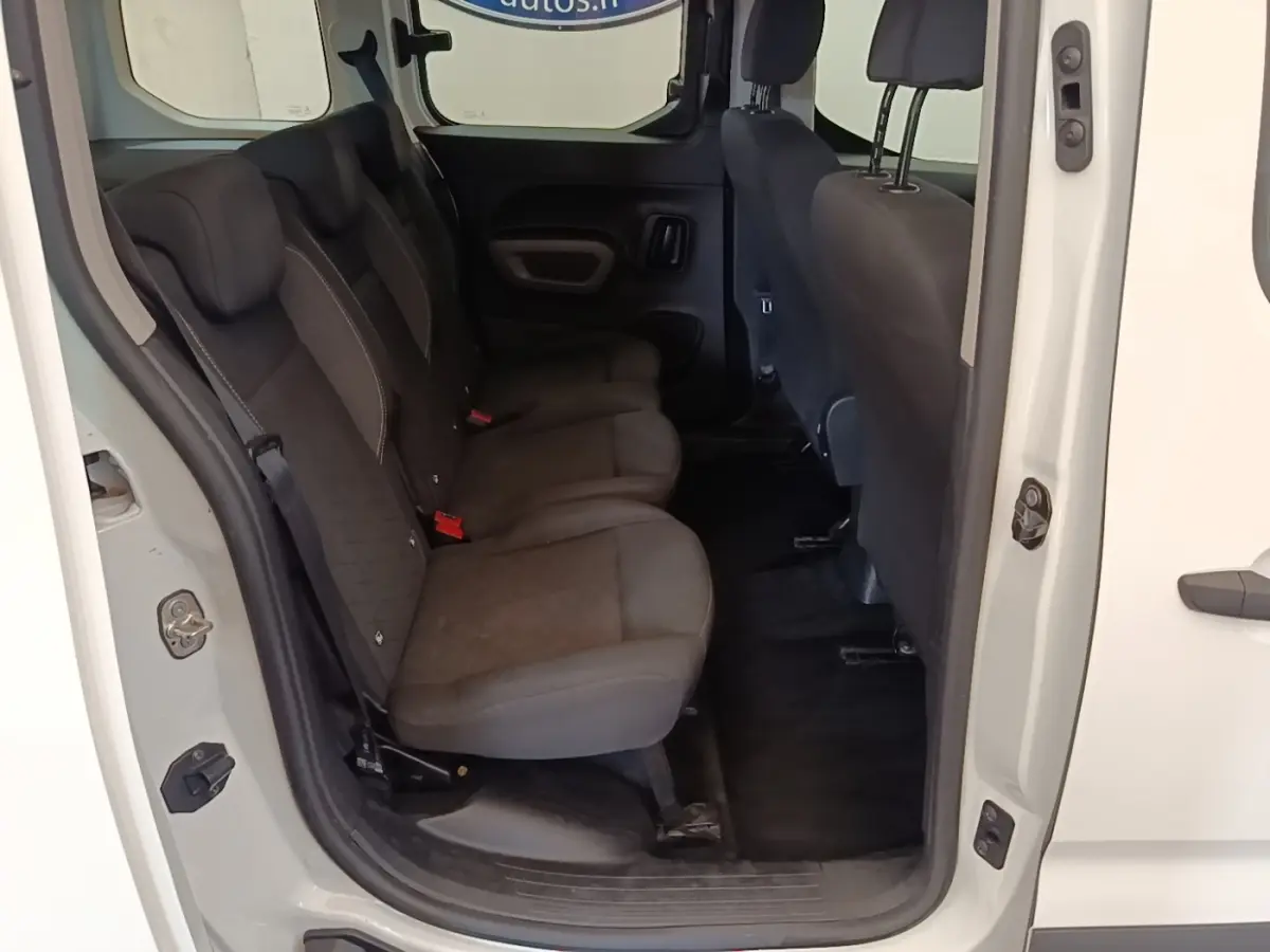 Vue intérieure côté gauche des sièges arrière noirs du Peugeot Rifter blanc, porte arrière ouverte.