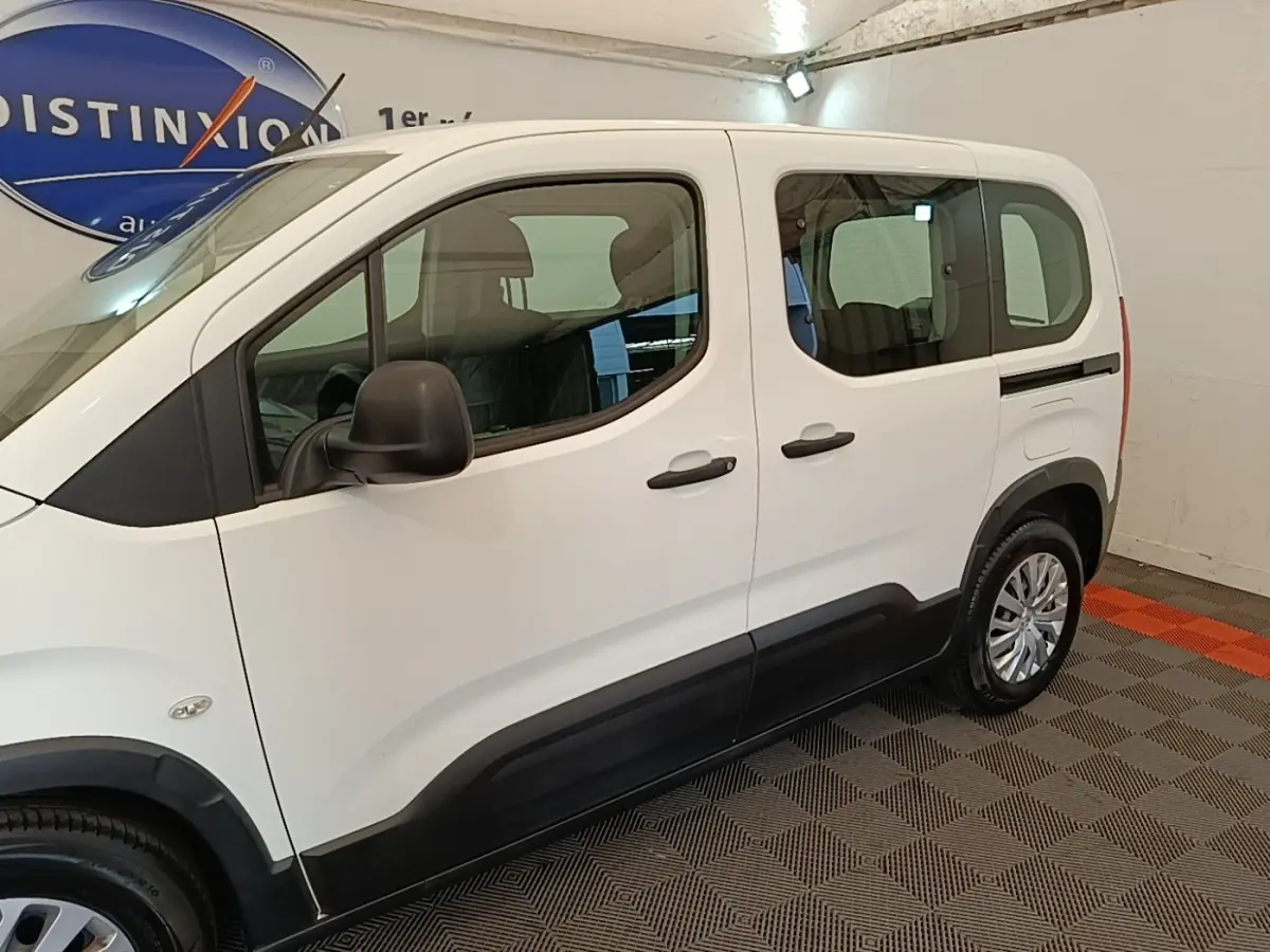 Vue de profil côté gauche du Peugeot Rifter blanc 2020 avec portes coulissantes et protections noires basses.