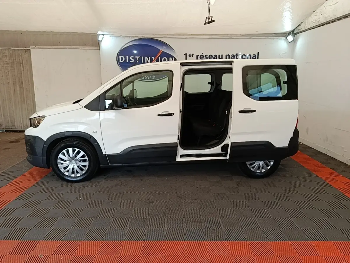 Peugeot Rifter blanc vue de profil droit avec porte coulissante arrière ouverte, intérieur sombre visible.