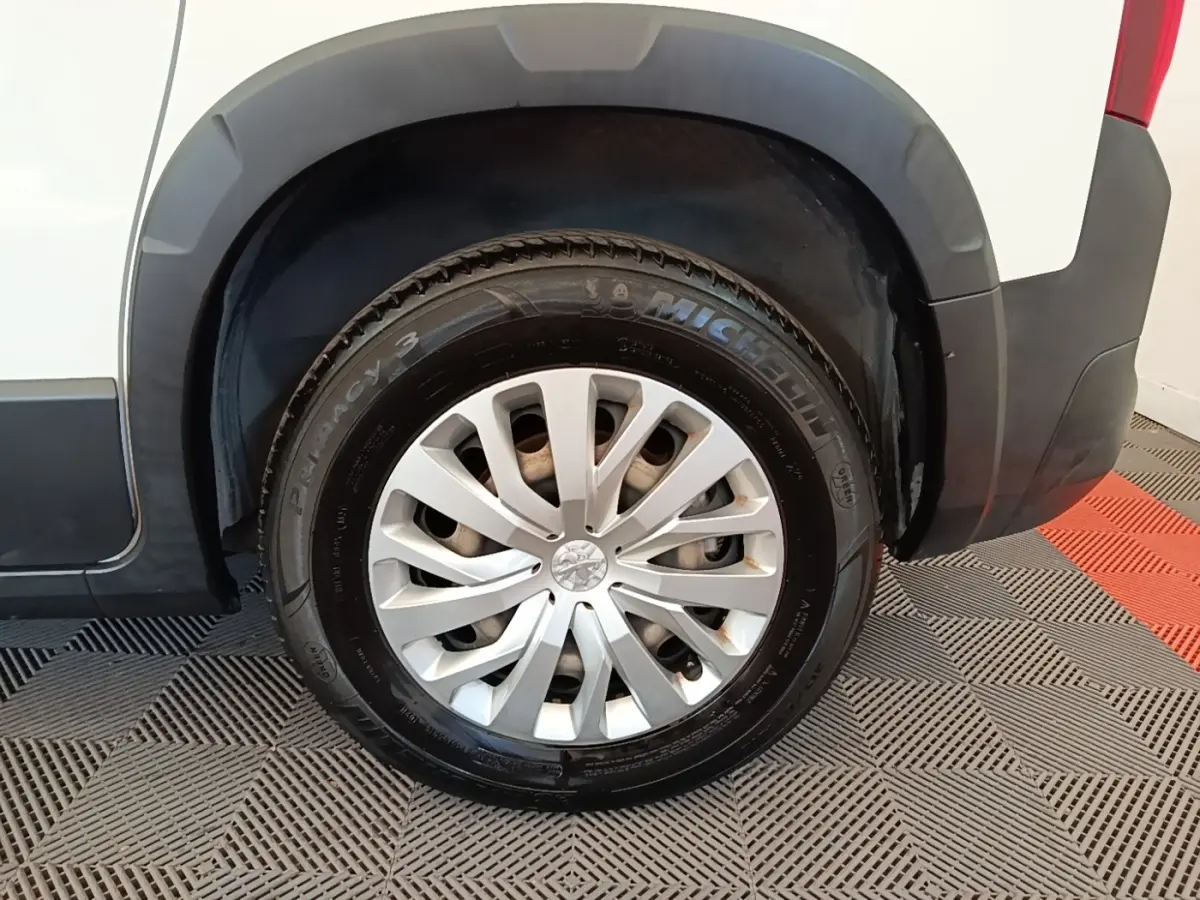 Gros plan sur la roue arrière droite d’un Peugeot Rifter blanc, mettant en valeur la jante argentée et le pneu Michelin.