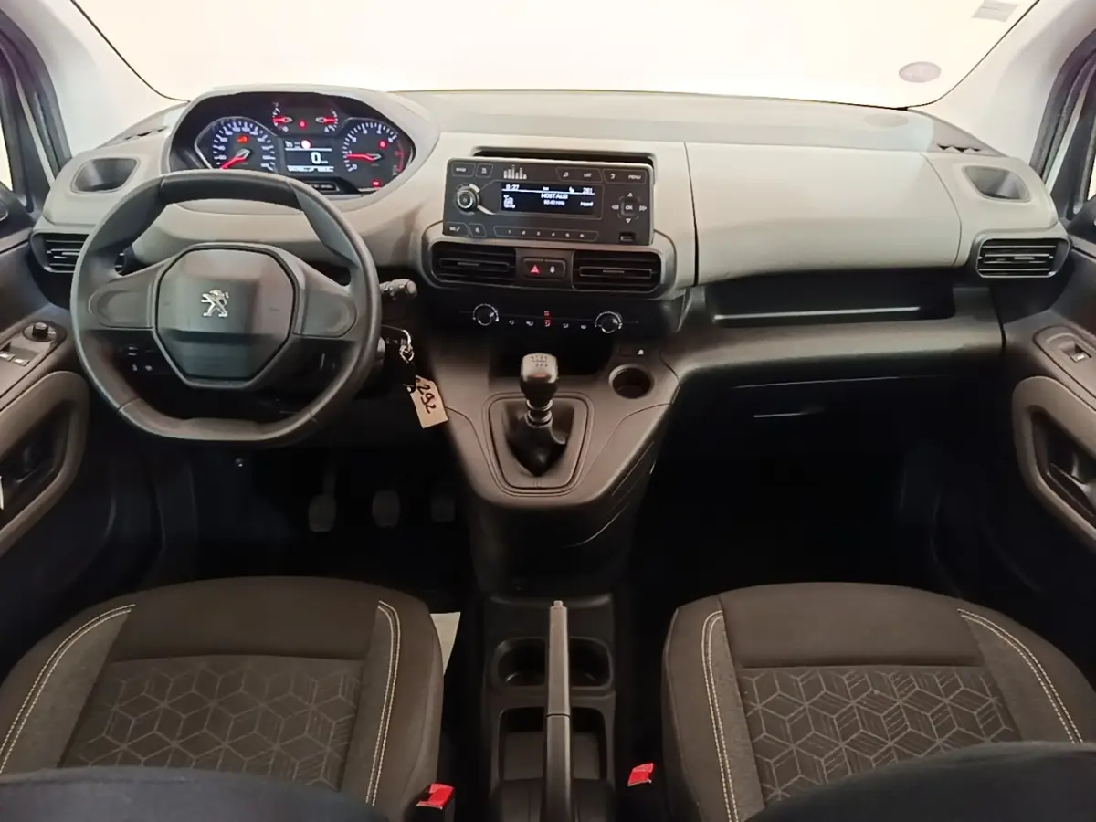 Vue intérieure avant du Peugeot Rifter blanc 2020, montrant le volant, tableau de bord et levier de vitesses manuel.