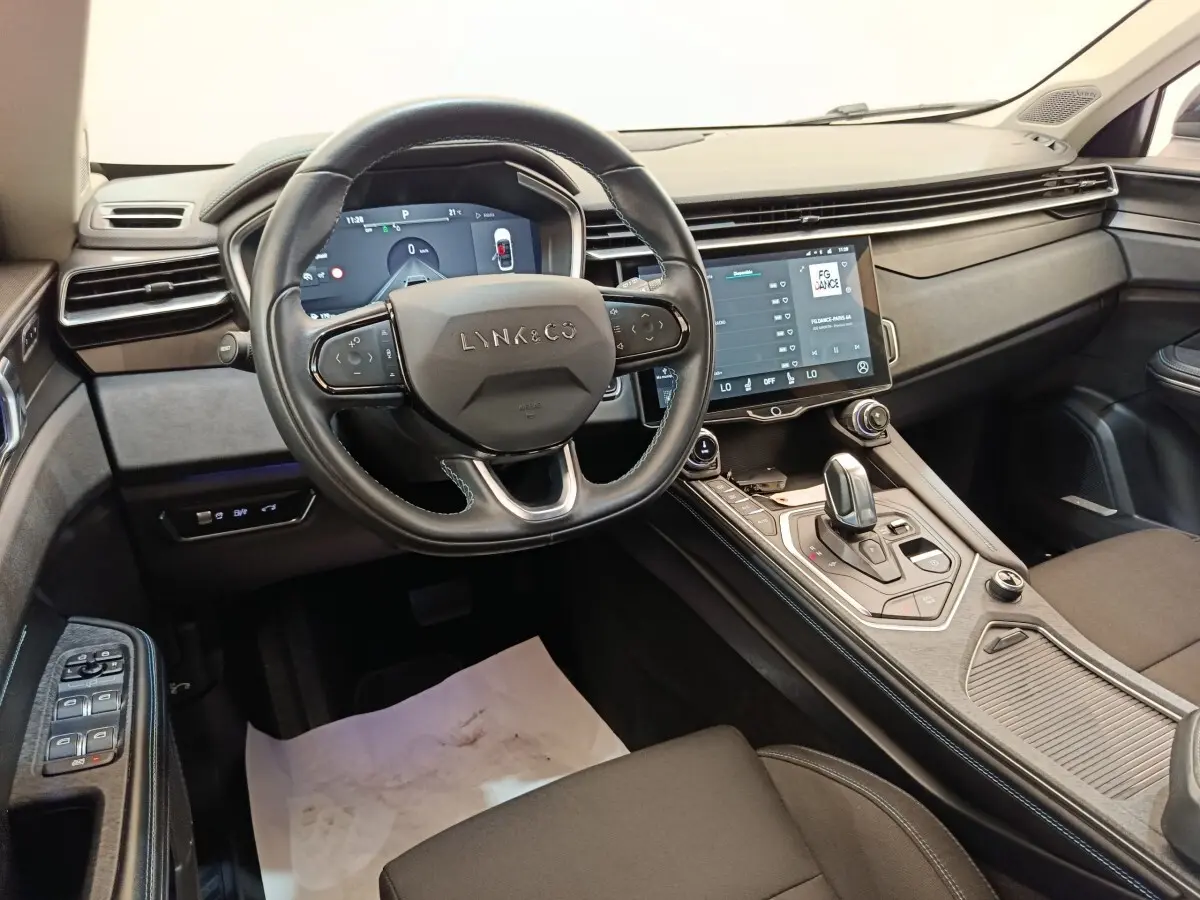 Intérieur du Lynk & Co 01 hybride rechargeable 2022, vue du poste de conduite avec volant multifonctions et écran tactile central.