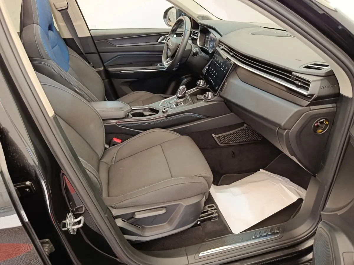Intérieur avant droit du Lynk & Co 01 hybride rechargeable 2022, sièges noirs et tableau de bord moderne avec écran tactile.