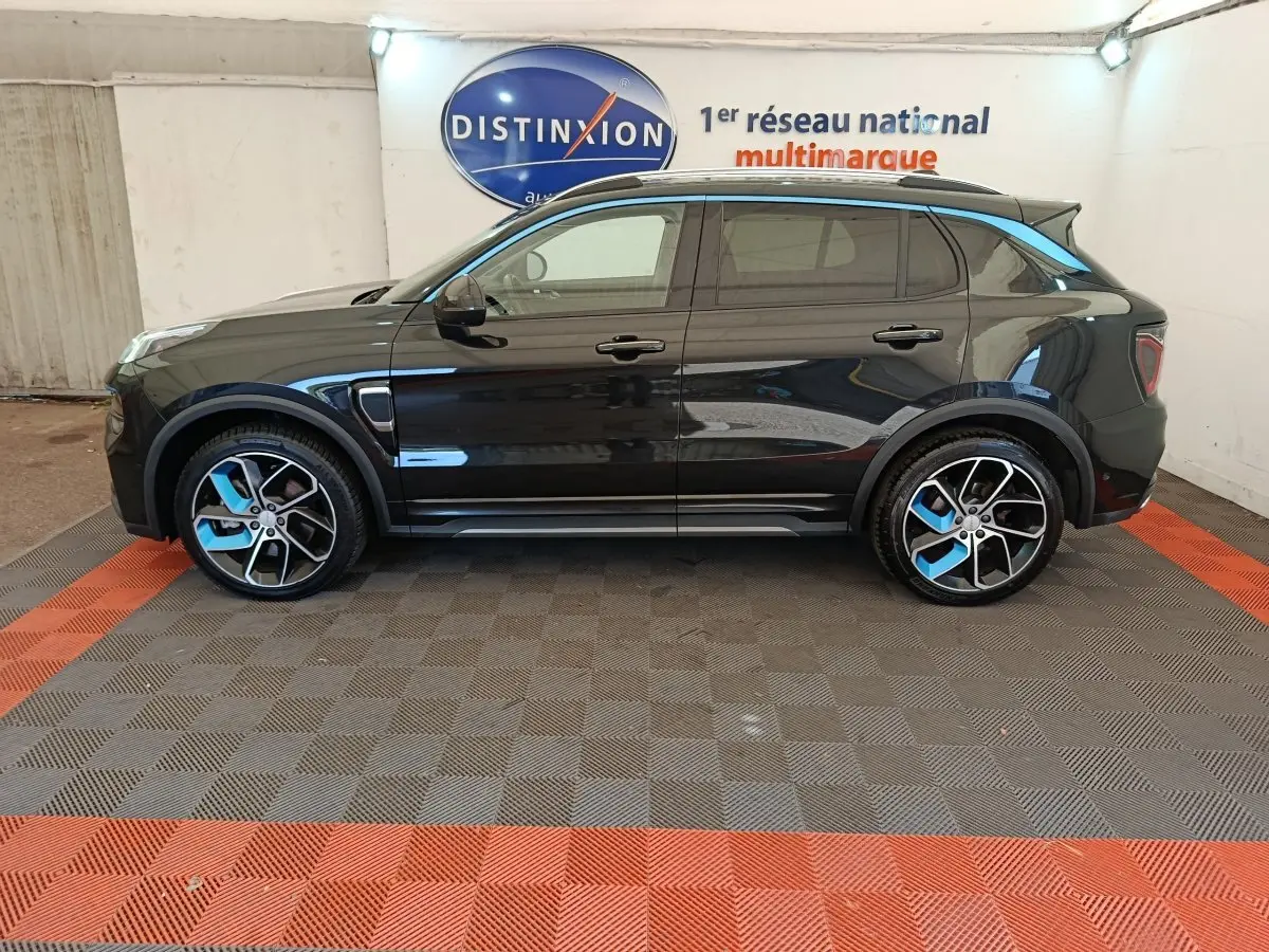 Vue de profil côté gauche du SUV LINK & CO 01 hybride rechargeable noir avec détails bleus sur jantes et toit.