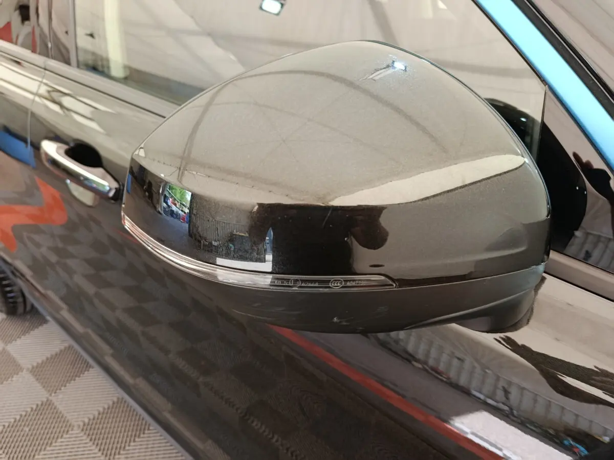 Gros plan sur le rétroviseur droit noir brillant du SUV bleu LINK & CO 01 hybride rechargeable 2022.