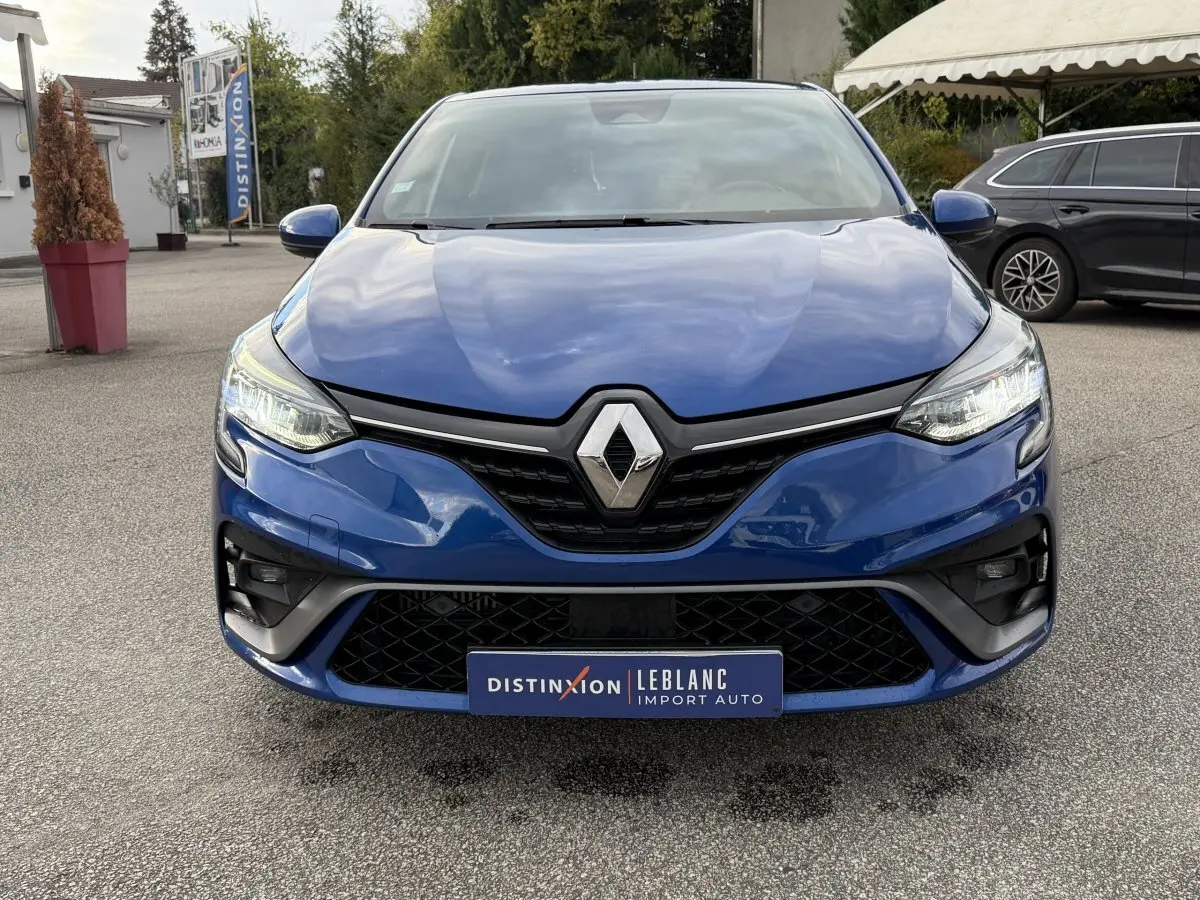 Vue frontale d'une Renault Clio RS Line bleu avec calandre noire et phares LED allumés.