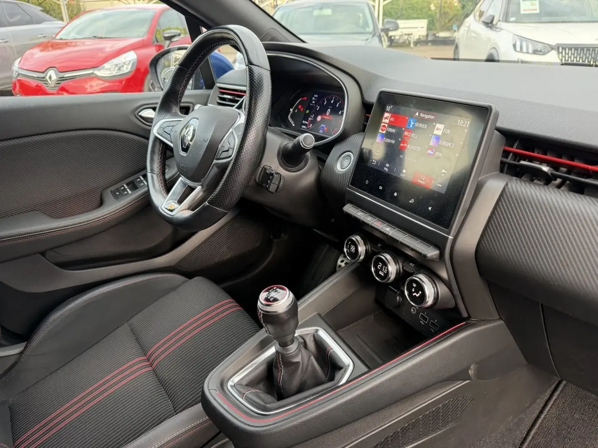 Vue intérieure côté conducteur de la Renault Clio RS Line 2021, volant cuir, écran tactile et levier de vitesses manuel.
